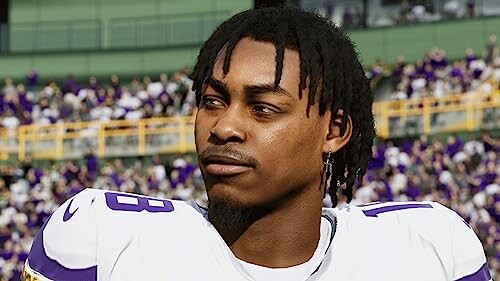 Football player in uniform with crowd in background.